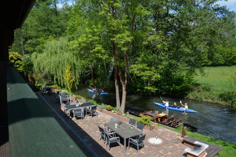 Blick von der Galerie auf die Tische und Stühle am Wasser