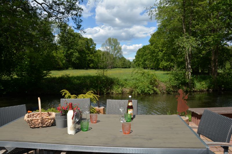 Getränke und Korb auf einem Tisch am Wasser