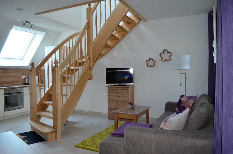 Blick auf die Einbauküche und Treppe in der Ferienwohnung Kahnschuppen